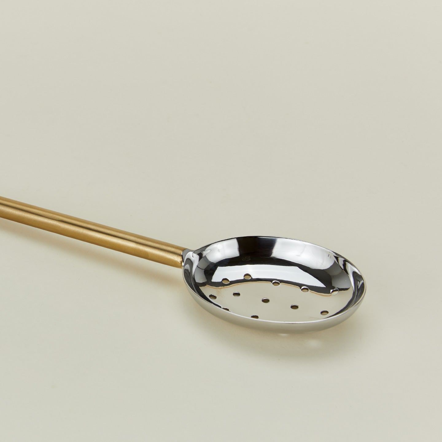 Close up view of Simple metal slotted spoon in brass
