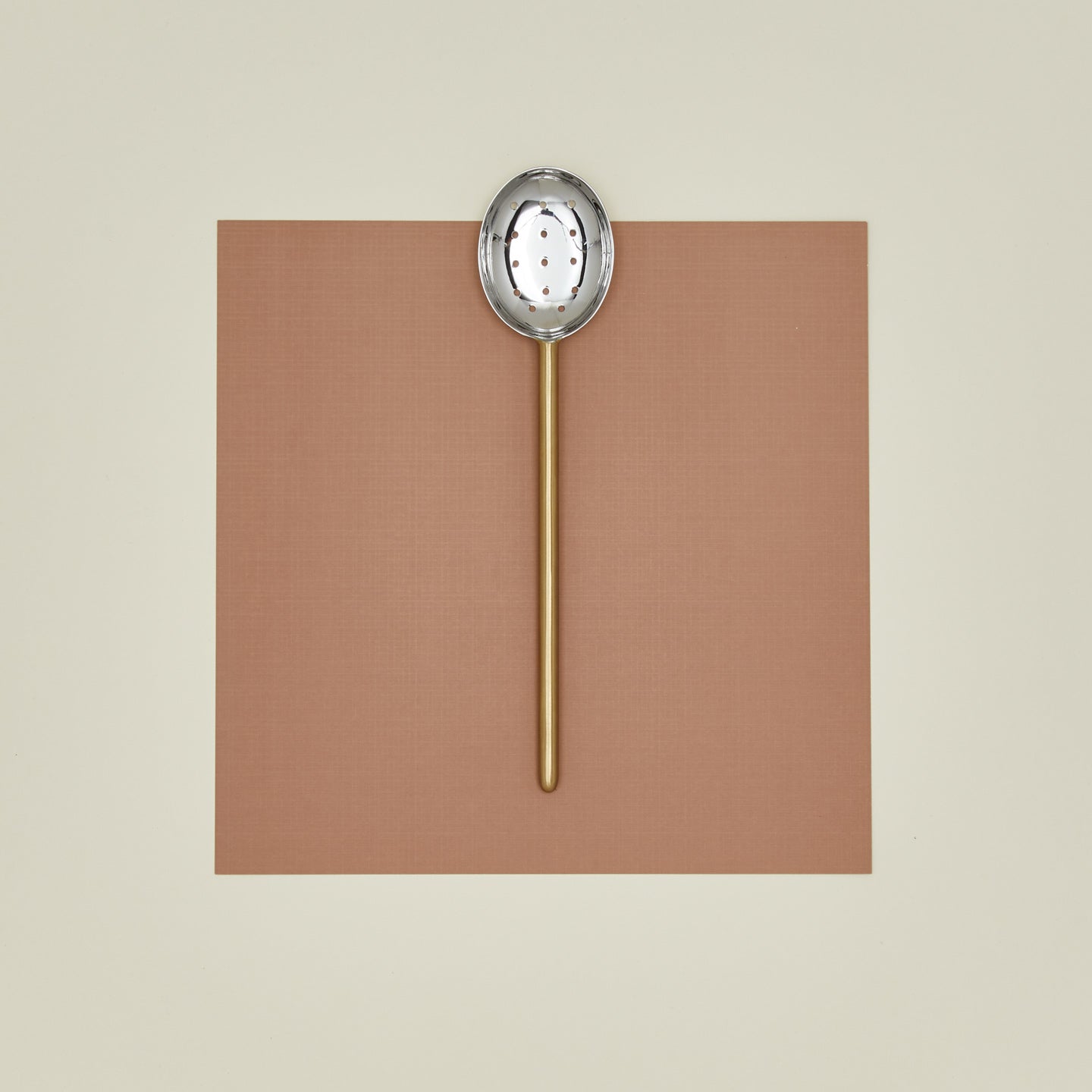 Simple metal slotted spoon in brass
