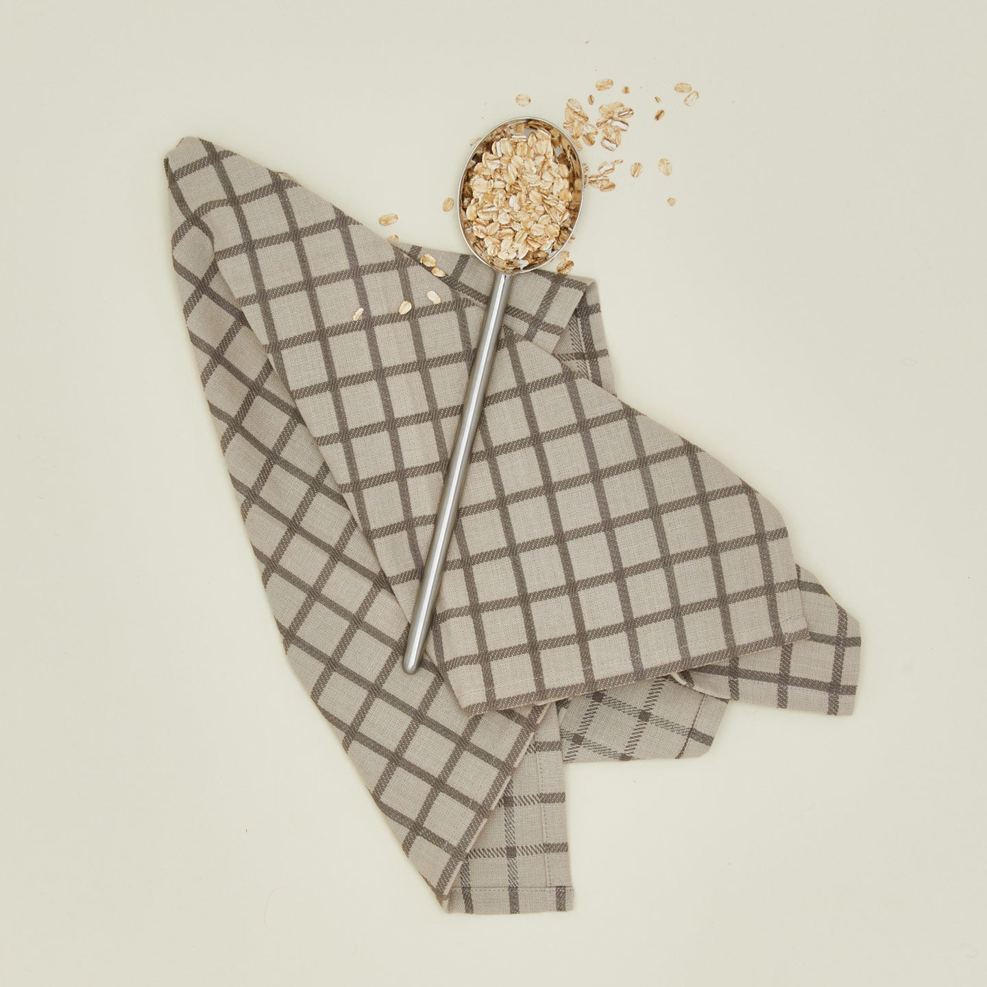 Simple metal spoon with dish towel and oats