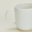 Close up view of simple porcelain dinnerware mug in white