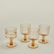 Three quarter view of Simple seeded glassware in Peach with water.