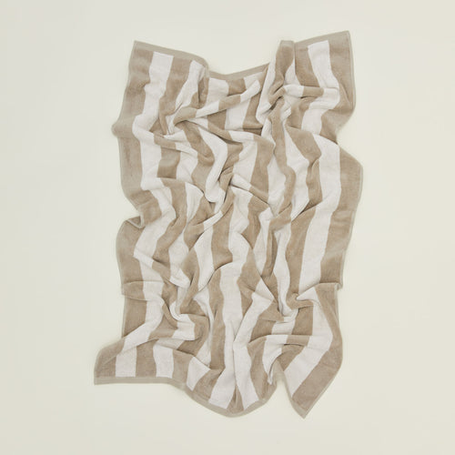 An overhead of a striped ivory and flax terry bath towel.