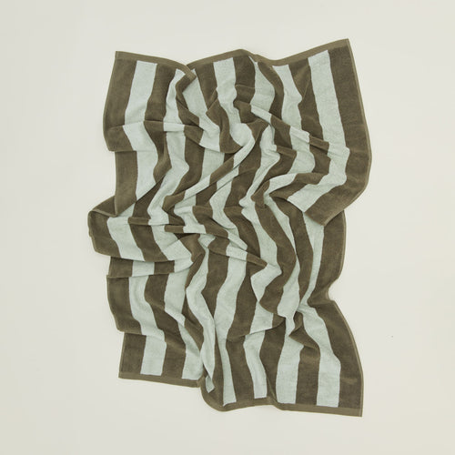 	An overhead of a striped olive and sage terry bath towel.