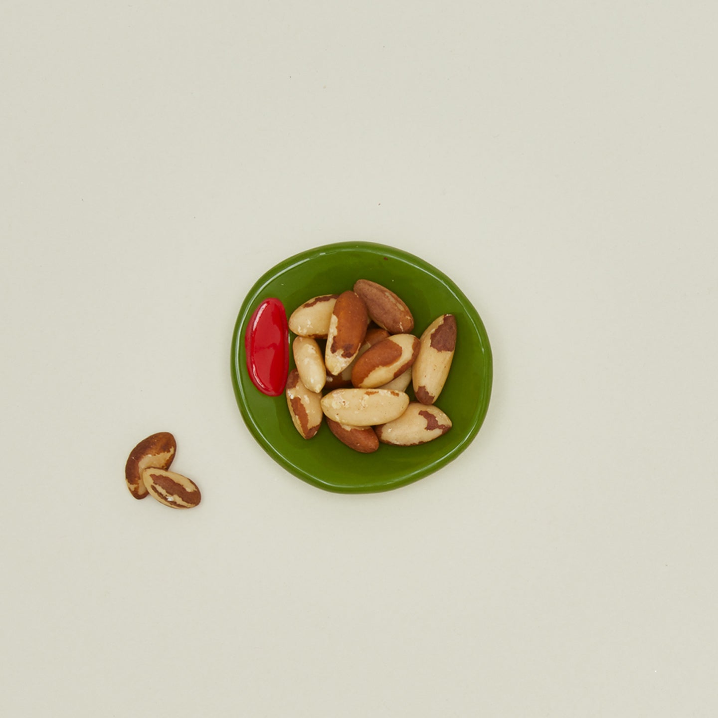 Overhead view of Olive Ceramic Dish with peanuts