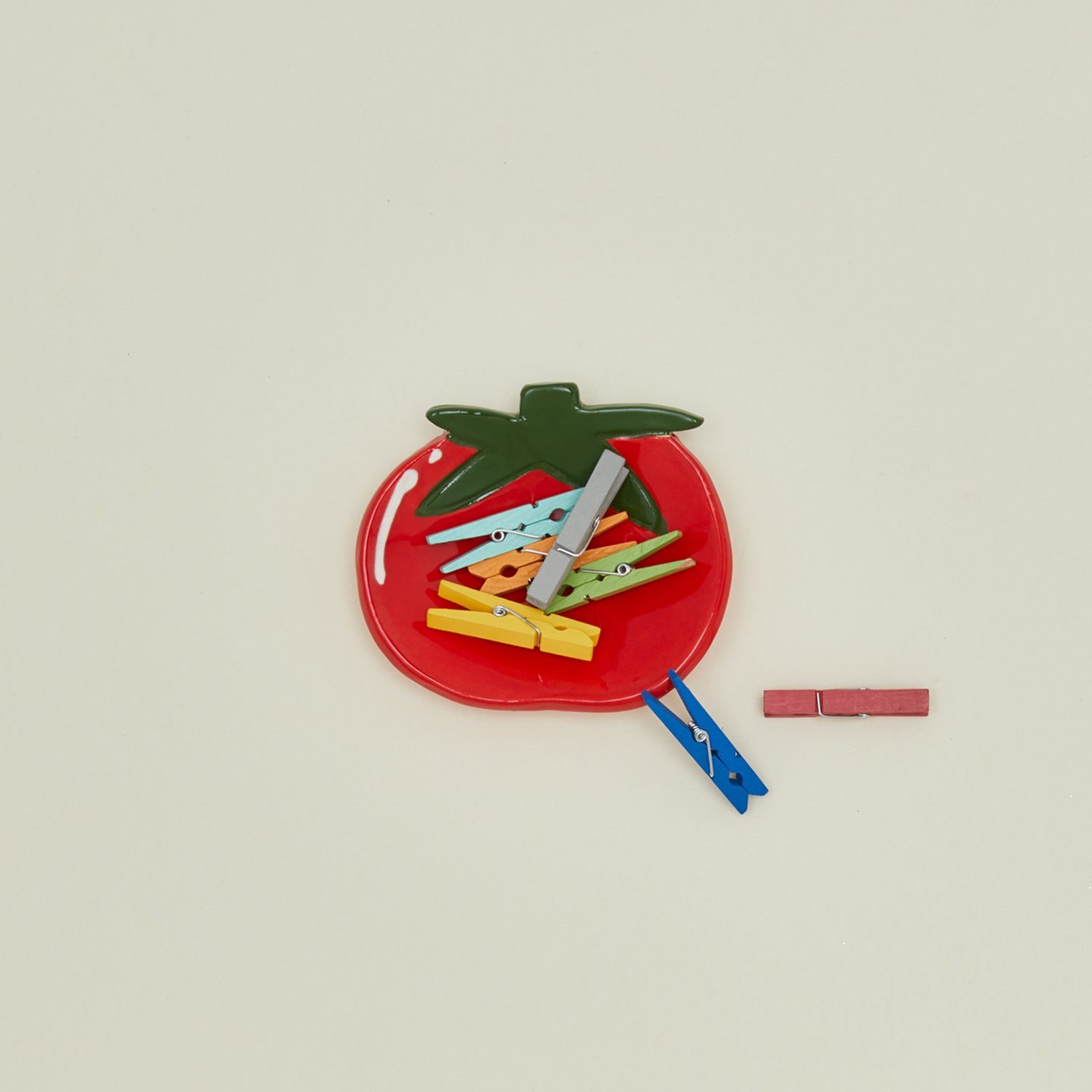 Overhead view of Tomato Ceramic Dish with clothespins