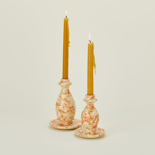 Large and small splatterware candlestick holders in ivory and bronze with candles