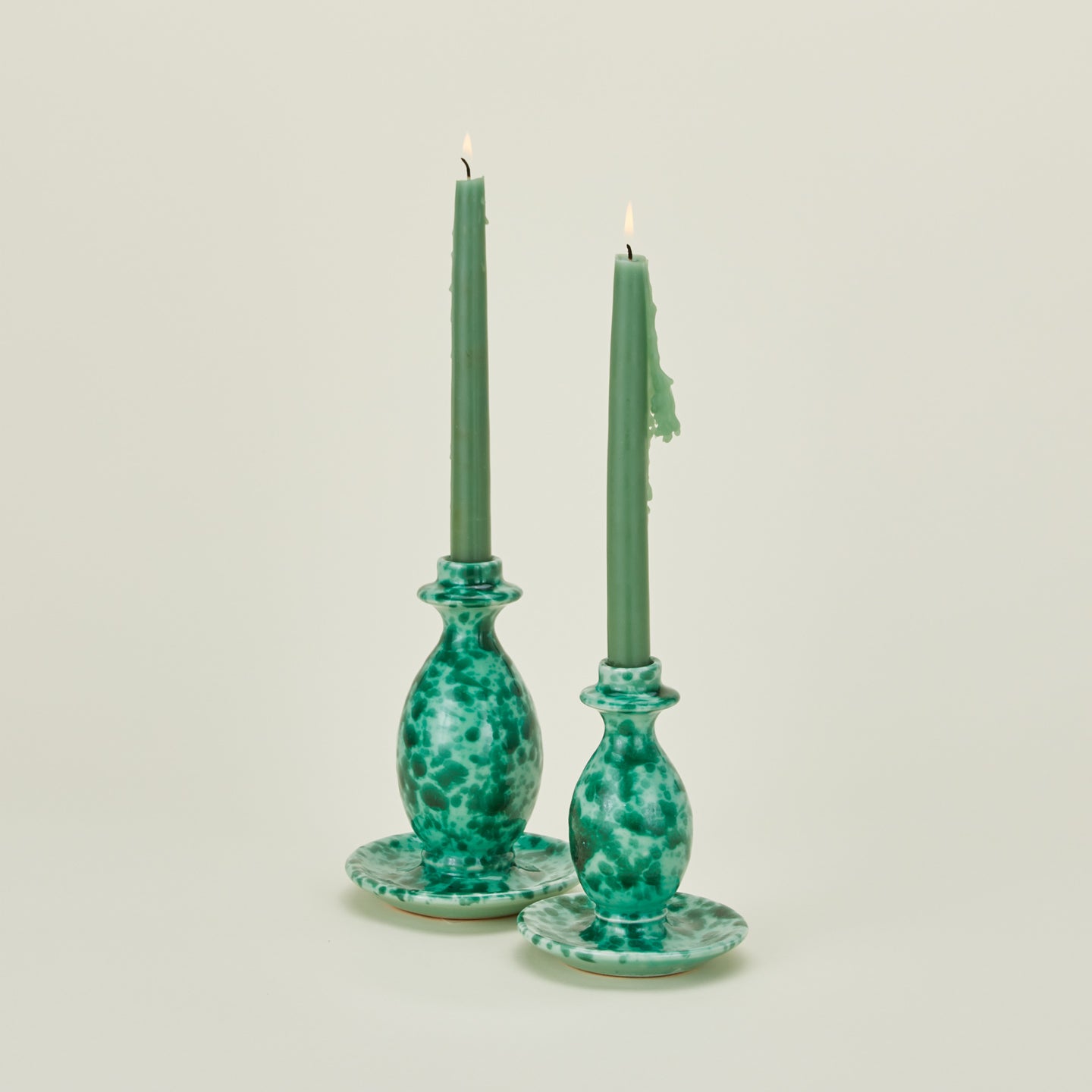 Large and small splatterware candlesticks in sage and green with candles