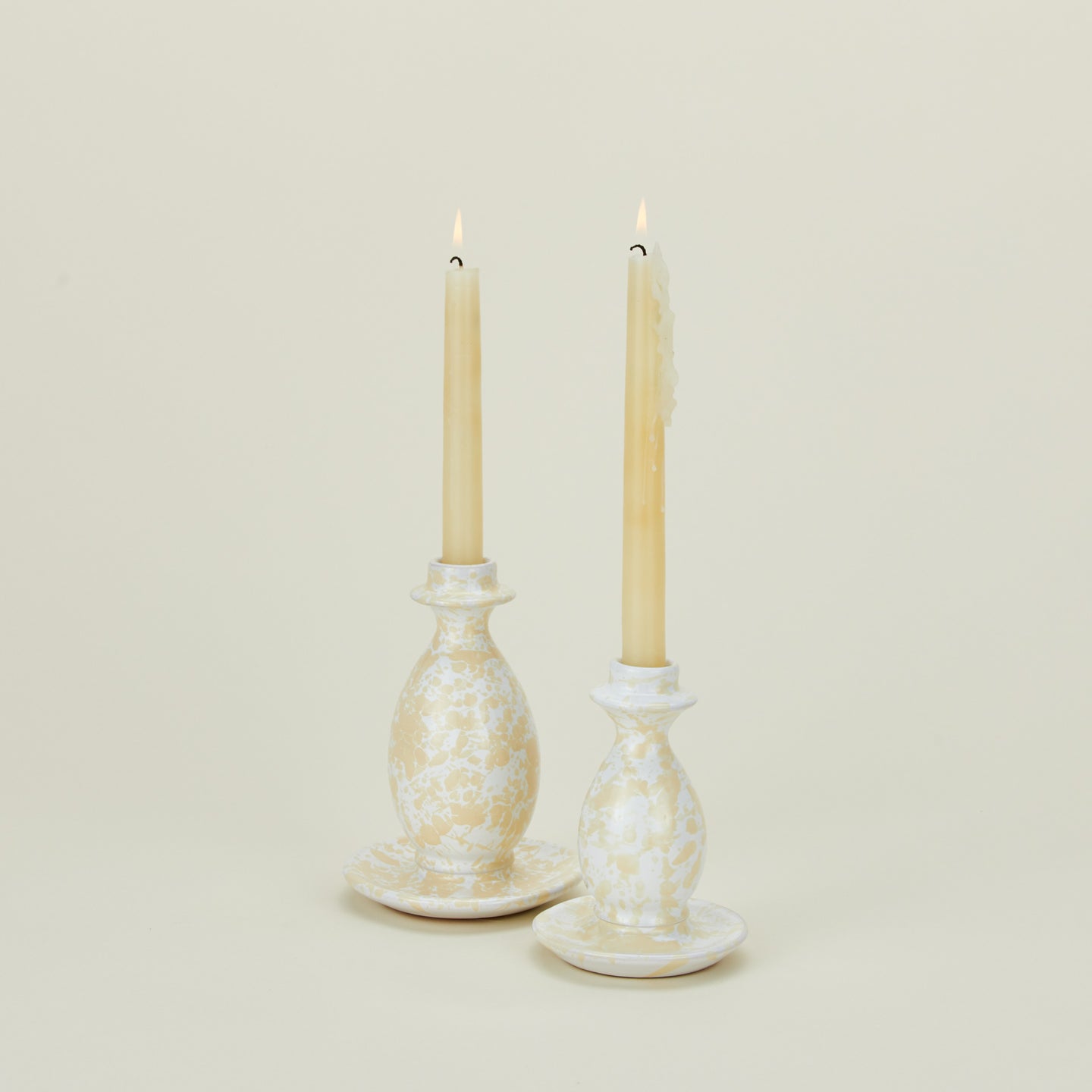 Splatterware candlestick holders in ivory and white with candles