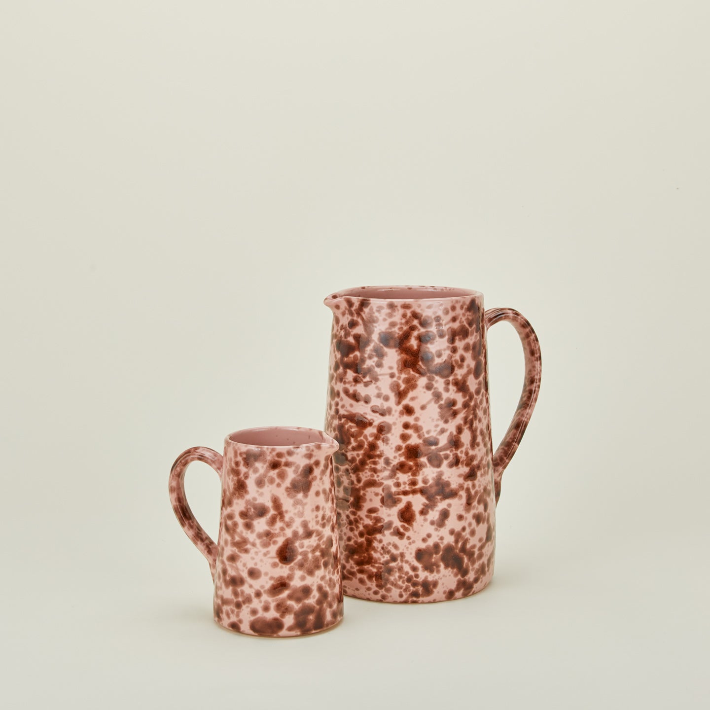 Large and small splatterware pitchers in blush and terracotta