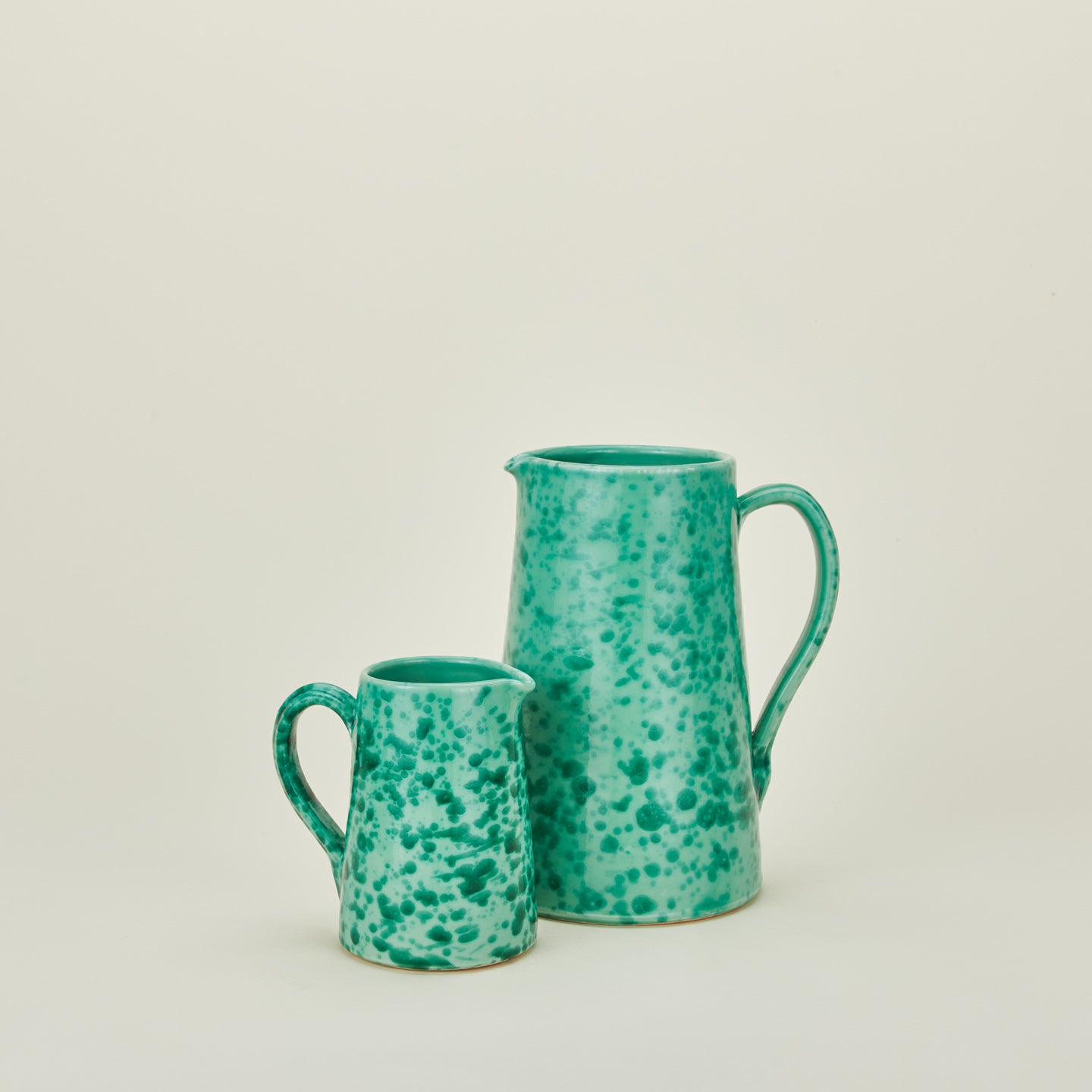 Large and small splatterware pitchers in sage and green