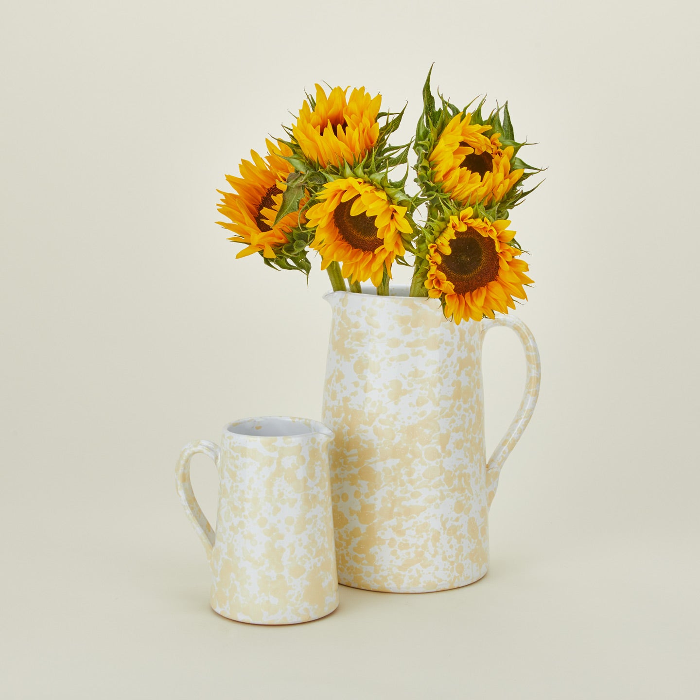 Large and small splatterware pitchers in ivory and white with sunflowers