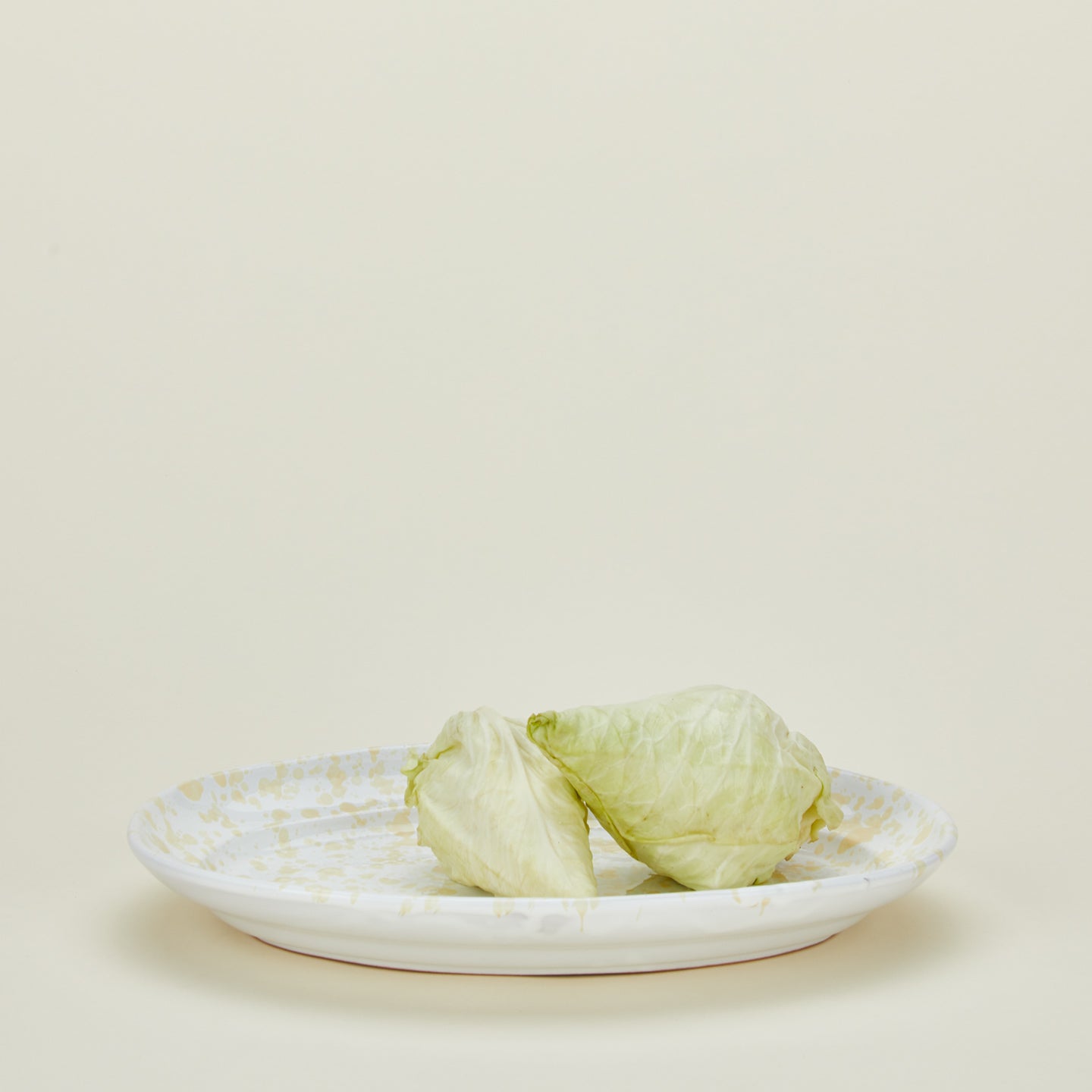 Splatterware serving platter in white and ivory with lettuce