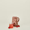 Small splatterware pitcher in blush and terracotta with glass and strawberries
