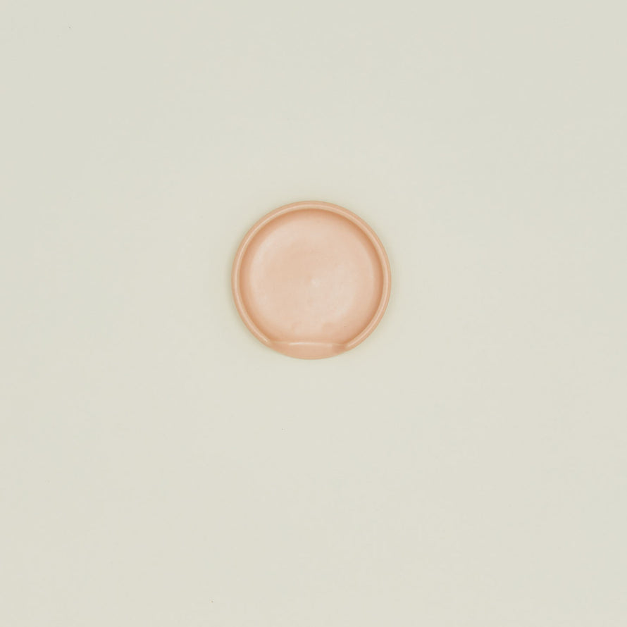 An overhead of a blush stoneware spoon rest.