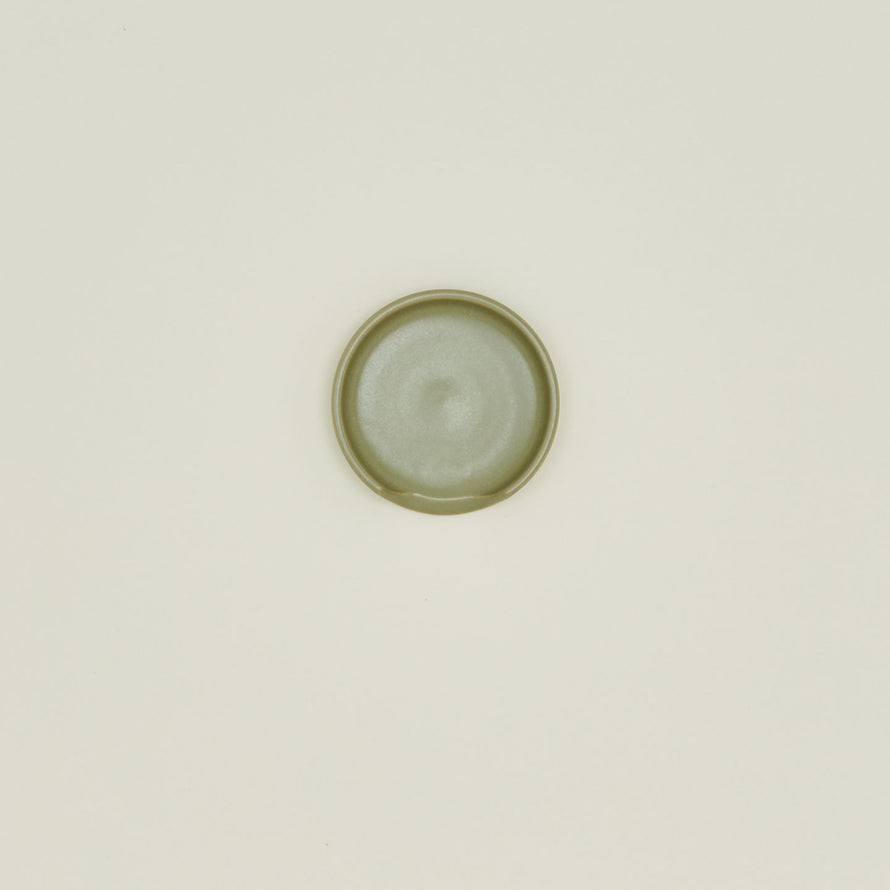 An overhead of an olive stoneware spoon rest.