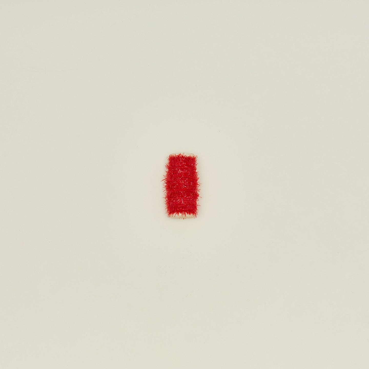 Tinsel ribbon in red on neutral background