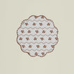 A round quilted placemat with a floral print in Constance brown.