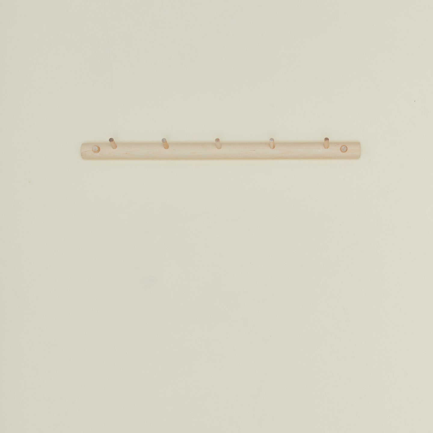 Large wooden coat rack on a beige wall
