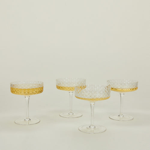 Four Veneziano coupe glasses with champagne.