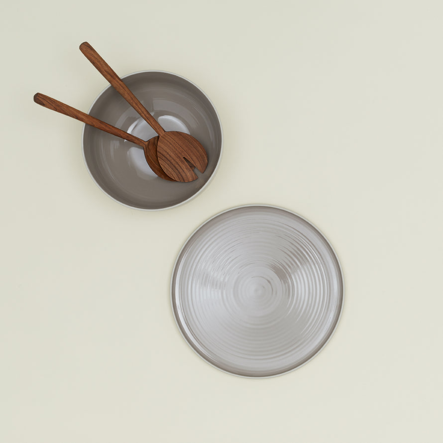 Essential Serving Bowl and Serving Platter in Light Grey, with wood serving utensils.
